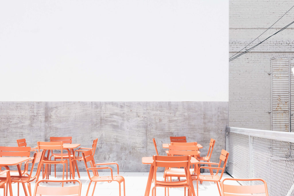 open space with orange tables and chairs.